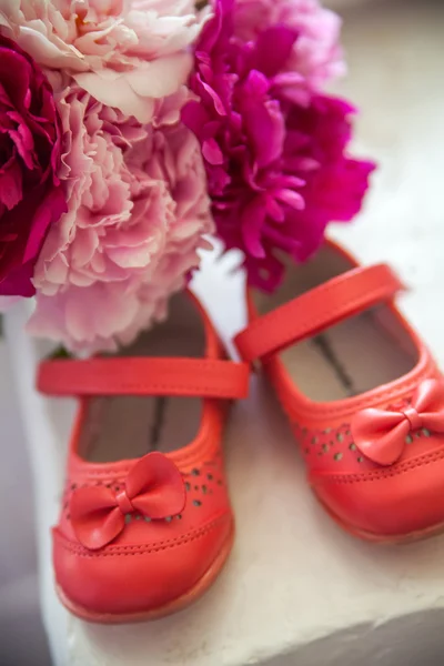 Boeket van lentebloemen en kinderschoenen — Stockfoto