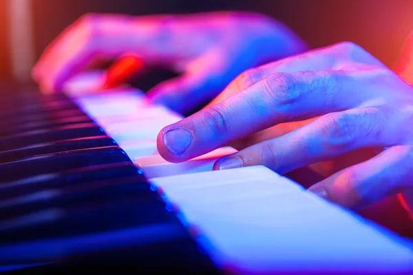 Manos de músico tocando el teclado en concierto con poca profundidad — Foto de Stock