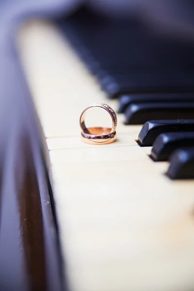 在老式的钢琴键上的结婚戒指 — 图库照片