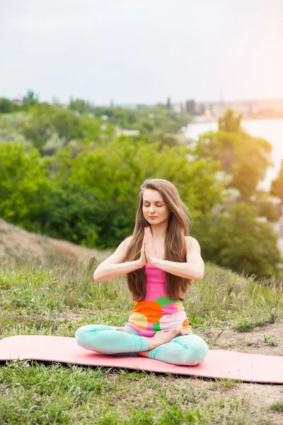 Güzel kadının doğa manzara üzerinde yoga egzersizleri yapması — Stok fotoğraf