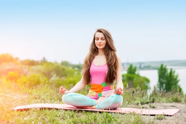 Güzel kadının doğa manzara üzerinde yoga egzersizleri yapması — Stok fotoğraf