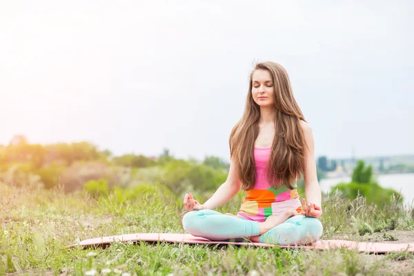 Güzel kadının doğa manzara üzerinde yoga egzersizleri yapması — Stok fotoğraf