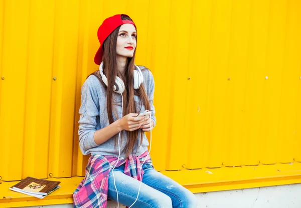 Chica joven escucha música en auriculares blancos — Foto de Stock