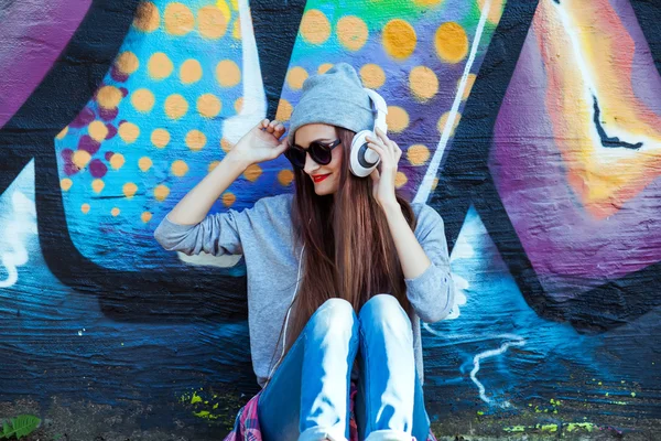 Menina escuta música em fones de ouvido brancos — Fotografia de Stock