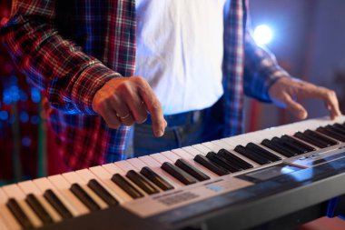 Dijital klavye sentezleyicisi çalan ellerin yakın çekimi enstrümanın karmaşık detaylarını ve müzisyenin yeteneğini gözler önüne seriyor. Müzikle ilgili içerik ve yaratıcı projeler için. Yumuşak odak