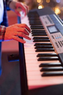 Dijital klavye sentezleyicisi çalan ellerin yakın çekimi enstrümanın karmaşık detaylarını ve müzisyenin yeteneğini gözler önüne seriyor. Müzikle ilgili içerik ve yaratıcı projeler için. Yumuşak odak
