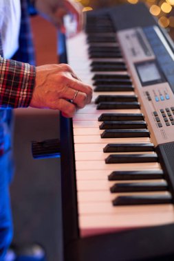 Dijital klavye sentezleyicisi çalan ellerin yakın çekimi enstrümanın karmaşık detaylarını ve müzisyenin yeteneğini gözler önüne seriyor. Müzikle ilgili içerik ve yaratıcı projeler için. Yumuşak odak