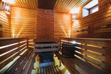 Tahta raflar ve saunanın saunasında tuğladan bir soba bulunan duvarlar. Sıcak banyo.