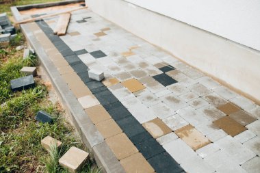 Taş bloklu bir evin etrafına kör bir alan inşa etmek. Dışarıdaki bir duvarcının işi.