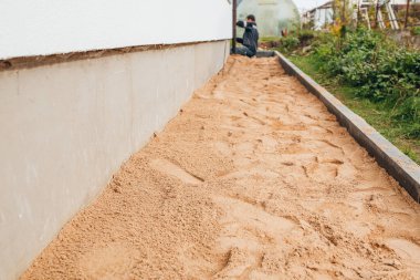 Asfalt döşemeden kör bir alan inşa etmek - temeli yağmur suyundan korumak için yeraltı haberleşme koruması kurmak