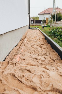 Taş bloklu bir evin etrafına kör bir alan inşa etmek. Dışarıdaki bir duvarcının işi.