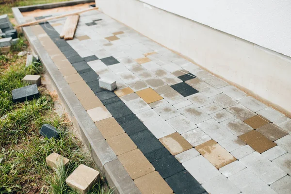 Taş bloklu bir evin etrafına kör bir alan inşa etmek. Dışarıdaki bir duvarcının işi.