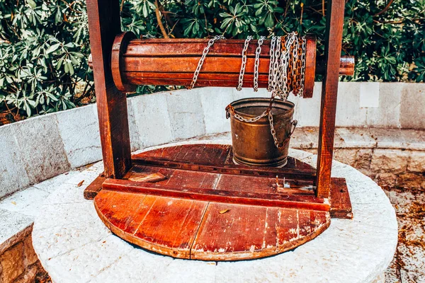 Vintage bucket on a chain by the well - clear groundwater from the ground