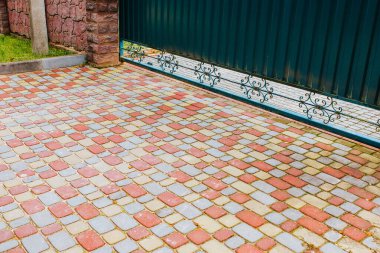 Özel bir evin avlusunda çok renkli kaldırım levhaları - yaya ve araba yolları - özel inşaat için kaldırım taşları döşeme ve yerleştirme