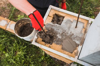 Beton bloklardan bir taş sütun inşaatı - tuğla bir çitin destekleyici yapısı