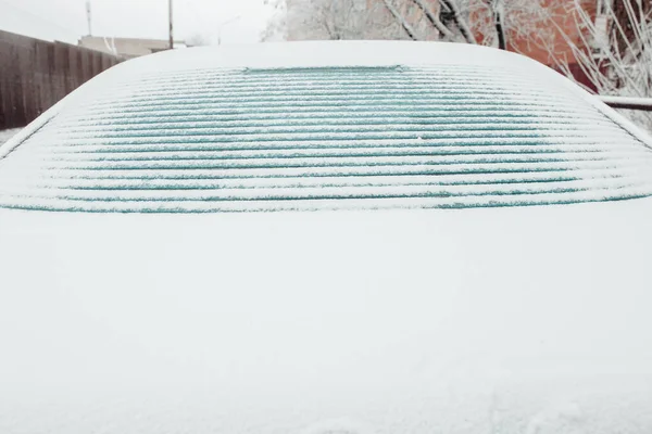 Ice melts on the rear window of the car - electric window heating with contact strips