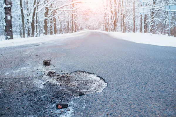Poor road repairs - chunks of asphalt fall out in winter from cold and moisture