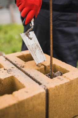 Beton bloklardan bir taş sütun inşaatı - tuğla bir çitin destekleyici yapısı