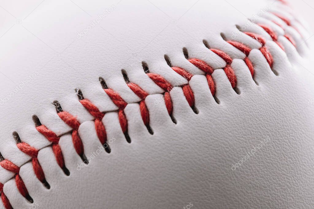 Close-up of a red thread seam on a white leather baseball - macro shot
