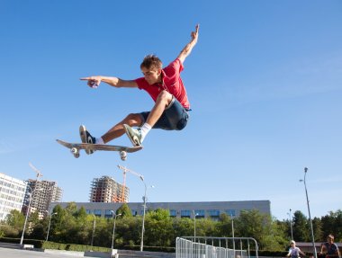male skateboarder jumping on skateboard clipart