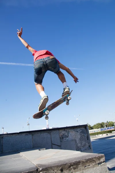 Männlicher Skateboarder springt auf Skateboard — Stockfoto