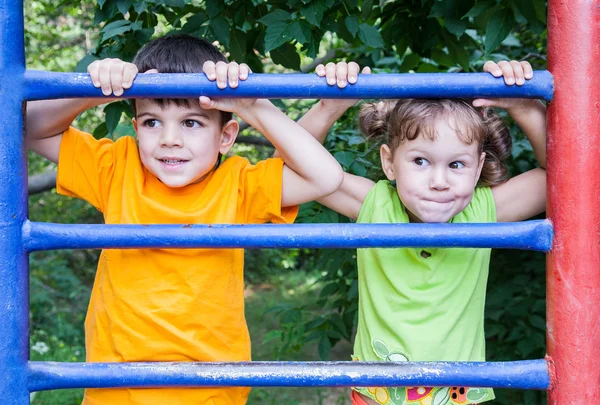 Ragazza e divertente ragazzo in su il parco giochi — Foto Stock