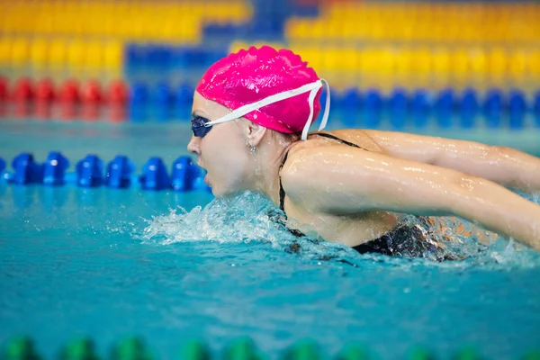 Mladá žena plave v bazénu — Stock fotografie