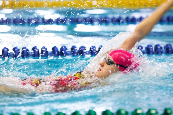 Mädchen schwimmt auf dem Rücken im Pool — Stockfoto