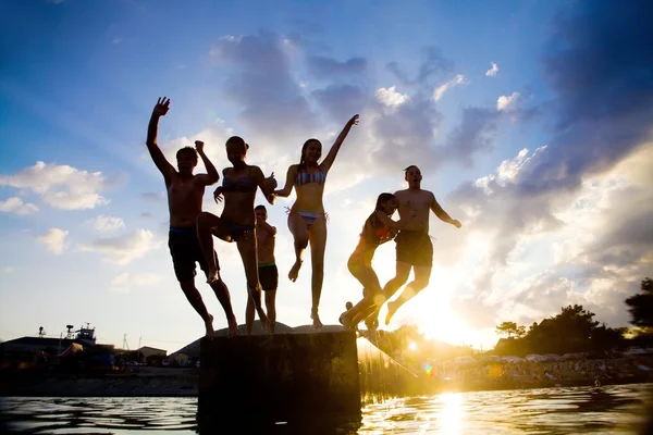 Tizenévesek leugranak a mólón a tengerbe — Stock Fotó