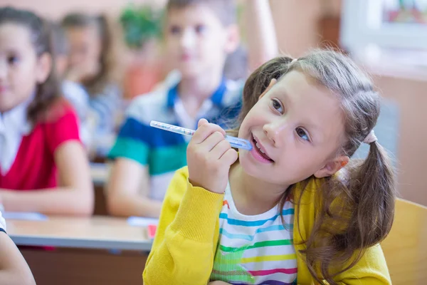 Écolière assise à un bureau de l'école — Photo