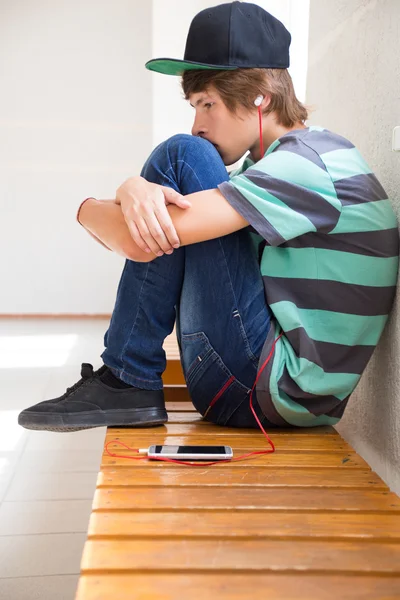 Tizenéves fiú hallgat zenét az iskolában — Stock Fotó