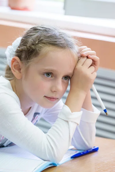 Schoolmeisje zit op een receptie van de school — Stockfoto