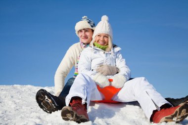 Genç çift kış tatilinde kayak merkezinde eğleniyor.