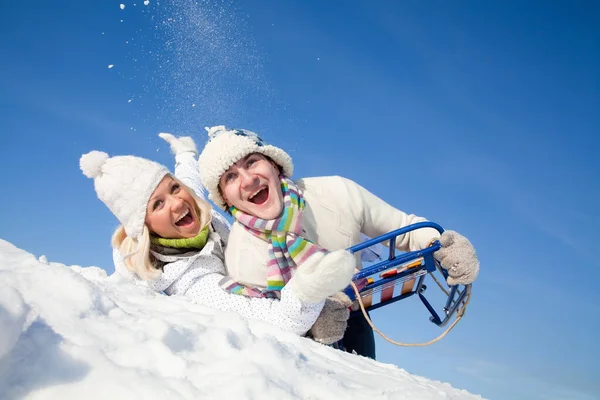 年轻夫妇在冬天的雪橇上翻山越岭玩得很开心 — 图库照片