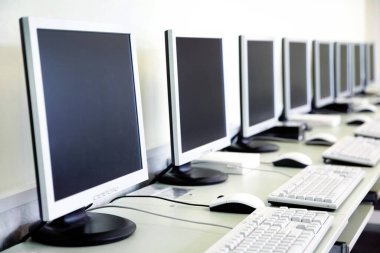 Masalarda uzun bir monitör serisi olan bilgisayar laboratuvarı.