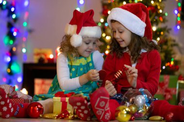 Noel Baba şapkalı iki küçük kız Noel partisinde hediyelerle