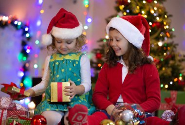 Noel Baba şapkalı iki küçük kız Noel partisinde hediyelerle