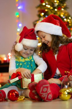 Noel Baba şapkalı iki küçük kız Noel partisinde hediyelerle