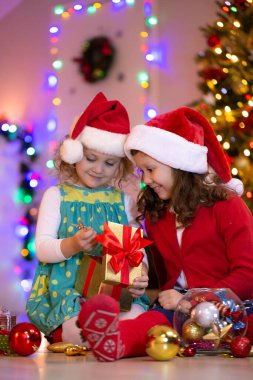 Noel Baba şapkalı iki küçük kız Noel partisinde hediyelerle