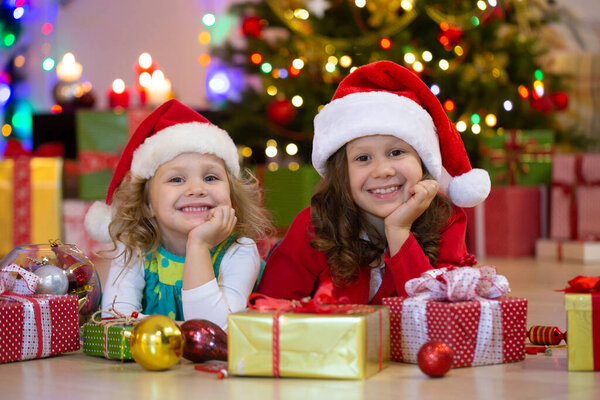 Dwie Dziewczynki Santa Claus Hat Prezentami Przyjęciu Świątecznym — Zdjęcie stockowe