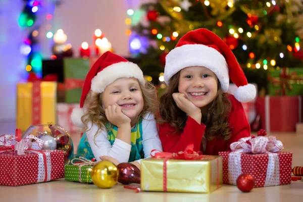 Noel Baba Şapkalı Iki Küçük Kız Noel Partisinde Hediyelerle — Stok fotoğraf