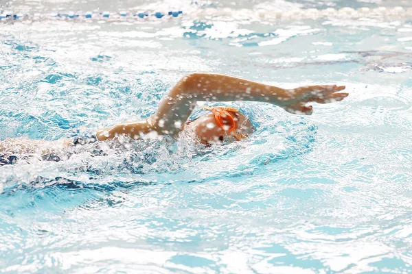 little girl swimming in the pool at the training in swimming