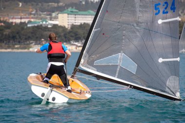  Erkek yatçı usta bir şekilde denizde bir yata liderlik ediyor. 