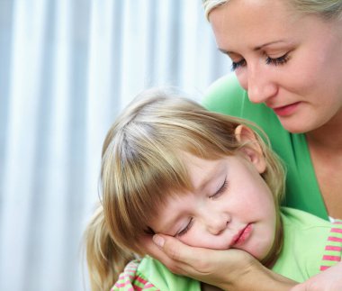 Sarışın bir anne ve küçük kızının evde portresi.. 