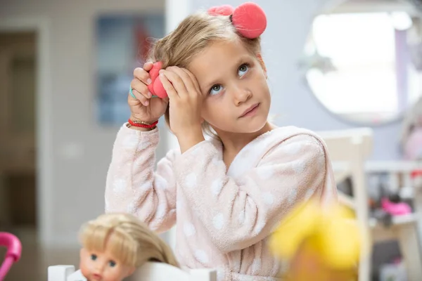 在儿童房里玩洋娃娃的可爱小姑娘的画像 — 图库照片