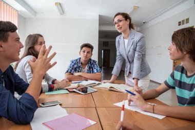 bir grup öğrenci okulda öğretmenle birlikte öğreniyor.