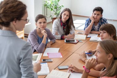 bir grup öğrenci okulda öğretmenle birlikte öğreniyor.