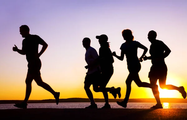 Grupo Jóvenes Corre Playa Hermoso Atardecer Verano —  Fotos de Stock