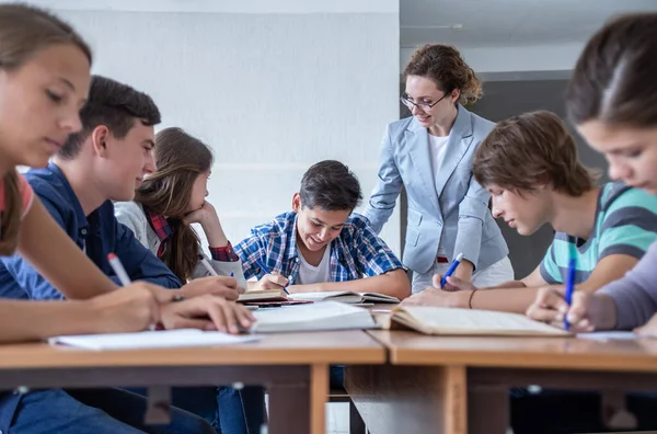 学校の教室で先生と一緒に学ぶ生徒のグループ — ストック写真