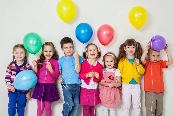 Большая Группа Счастливых Детей Воздушными Шарами Белой Стены — стоковое фото